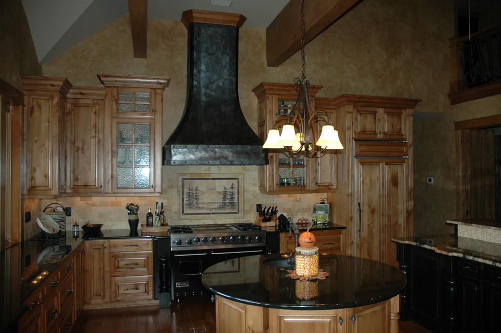 シアトルにある高級な中くらいなトラディショナルスタイルのおしゃれなキッチン (レイズドパネル扉のキャビネット、ステンレスキャビネット、木材カウンター、ベージュキッチンパネル、濃色無垢フローリング、磁器タイルのキッチンパネル、パネルと同色の調理設備) の写真