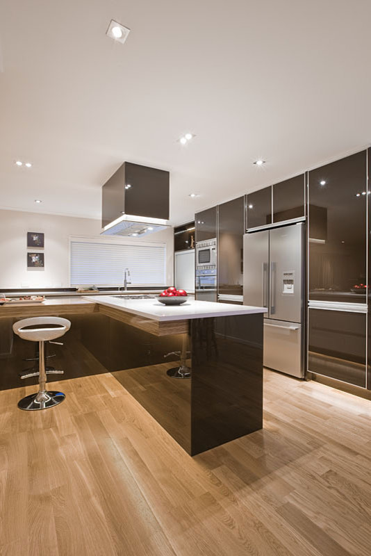 Foto di una grande cucina minimal con lavello sottopiano, ante lisce, elettrodomestici in acciaio inossidabile e parquet chiaro