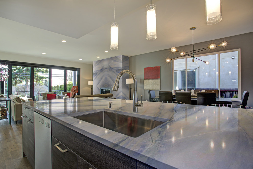 Cette photo montre une cuisine ouverte parallèle avec un plan de travail en quartz, un électroménager en acier inoxydable, parquet peint, îlot, un sol beige et un plan de travail bleu.