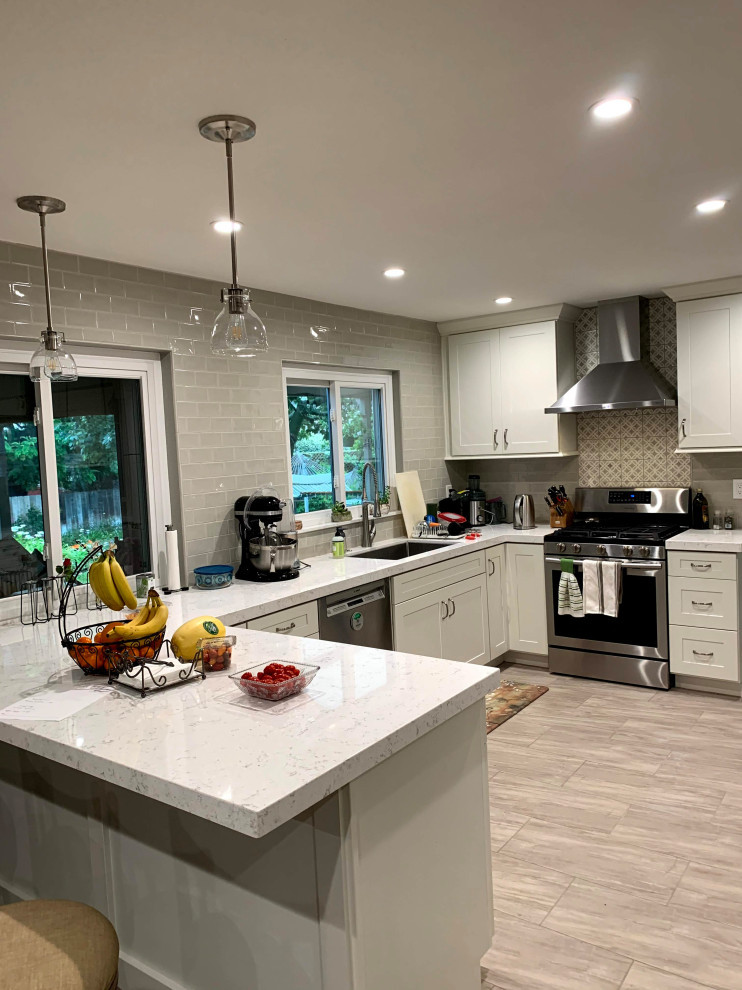 Medium sized classic u-shaped kitchen/diner in San Diego with a submerged sink, shaker cabinets, white cabinets, engineered stone countertops, grey splashback, metro tiled splashback, stainless steel appliances, porcelain flooring, an island, grey floors and white worktops.