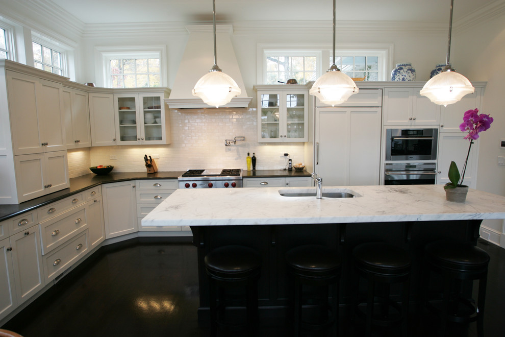 Idéer för att renovera ett vintage kök, med en undermonterad diskho, luckor med infälld panel, vita skåp, marmorbänkskiva, vitt stänkskydd, stänkskydd i tunnelbanekakel och integrerade vitvaror