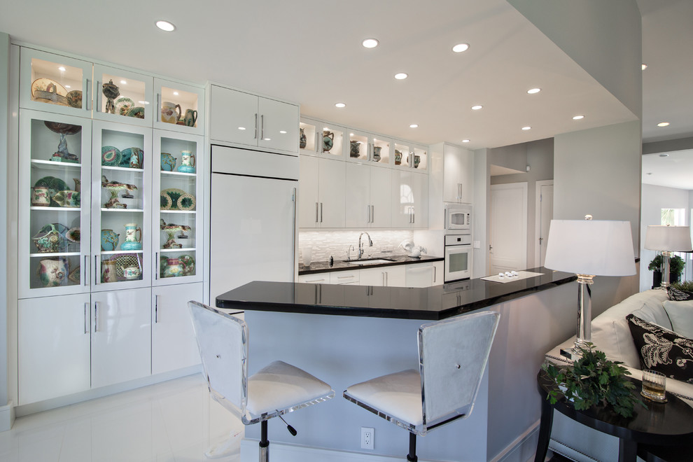Design ideas for a contemporary open plan kitchen in Miami with flat-panel cabinets, a submerged sink, white cabinets, white splashback and integrated appliances.