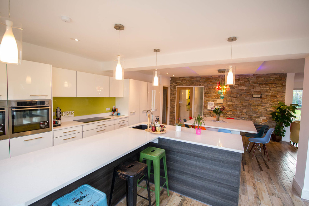 Idee per una cucina abitabile contemporanea con ante bianche e pavimento in legno massello medio