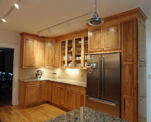Inspiration for a timeless eat-in kitchen remodel in Boston with an undermount sink, raised-panel cabinets, medium tone wood cabinets, granite countertops, beige backsplash and stainless steel appliances