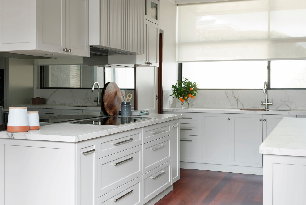 Bild på ett stort vintage flerfärgad flerfärgat kök, med en undermonterad diskho, skåp i shakerstil, grå skåp, bänkskiva i koppar, grått stänkskydd, glaspanel som stänkskydd, svarta vitvaror, mörkt trägolv, en köksö och brunt golv