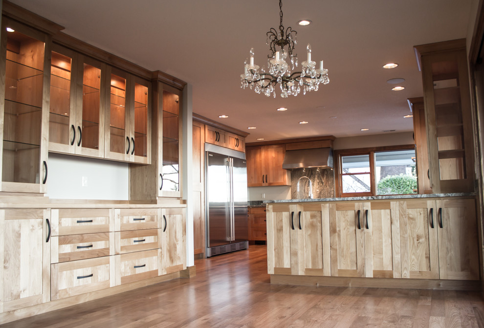 Example of a large eclectic medium tone wood floor open concept kitchen design in Portland with an undermount sink, recessed-panel cabinets, light wood cabinets, granite countertops, stone slab backsplash, stainless steel appliances and an island