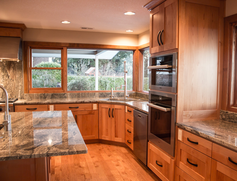 Foto på ett stort eklektiskt kök med öppen planlösning, med en undermonterad diskho, luckor med infälld panel, skåp i ljust trä, granitbänkskiva, stänkskydd i sten, rostfria vitvaror, mellanmörkt trägolv och en köksö