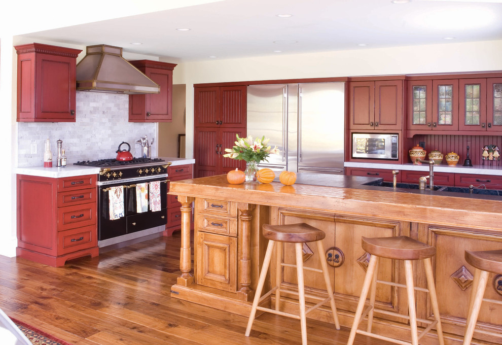Klassische Küche in L-Form mit roten Schränken, Doppelwaschbecken, Kassettenfronten, Küchenrückwand in Grau und Küchengeräten aus Edelstahl in Denver