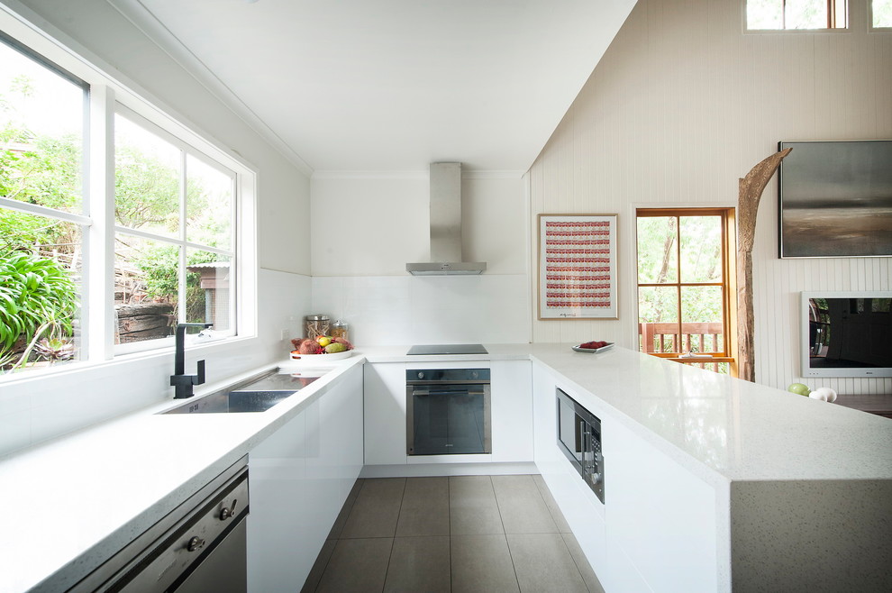 Medium sized contemporary u-shaped open plan kitchen in Melbourne with a submerged sink, flat-panel cabinets, white cabinets, engineered stone countertops, yellow splashback, metro tiled splashback, stainless steel appliances, ceramic flooring and an island.