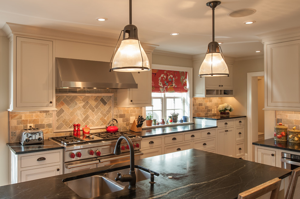Example of a classic l-shaped enclosed kitchen design in Philadelphia with a double-bowl sink, beaded inset cabinets, white cabinets, multicolored backsplash, stainless steel appliances, travertine backsplash and soapstone countertops
