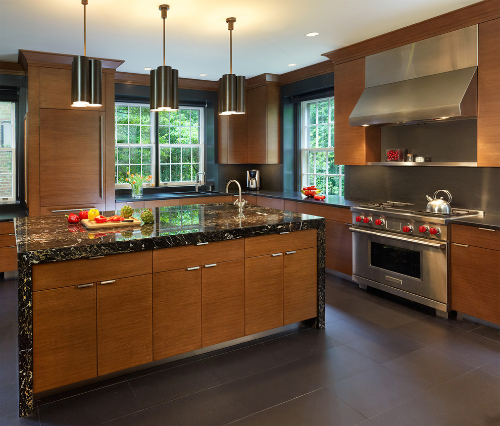 Exemple d'une cuisine tendance en U et bois brun avec un placard à porte plane, un plan de travail en granite, une crédence grise, un électroménager en acier inoxydable, un sol en carrelage de céramique et îlot.