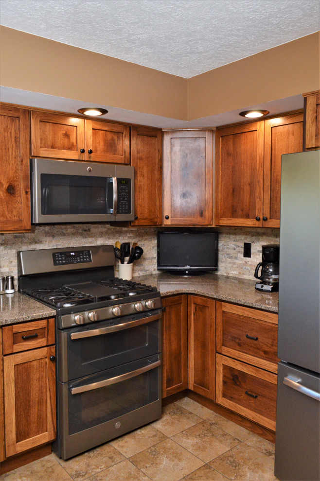 Foto på ett mellanstort rustikt brun kök, med en undermonterad diskho, skåp i shakerstil, skåp i mellenmörkt trä, bänkskiva i kvartsit, grått stänkskydd, stänkskydd i stenkakel, rostfria vitvaror, klinkergolv i keramik, en halv köksö och beiget golv
