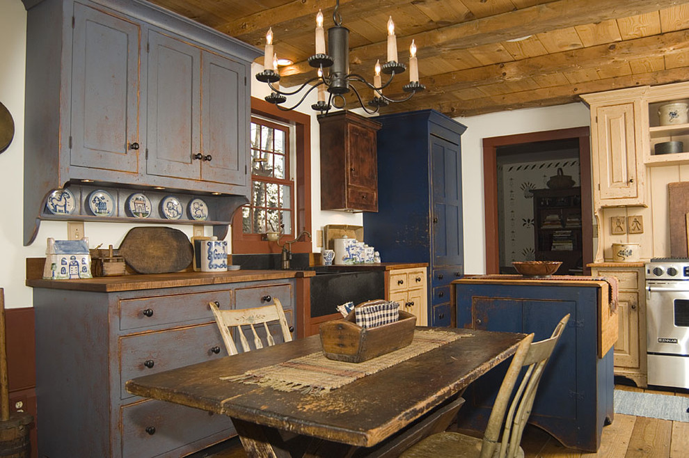 Пример оригинального дизайна: кухня в стиле рустика с деревянной столешницей и искусственно-состаренными фасадами