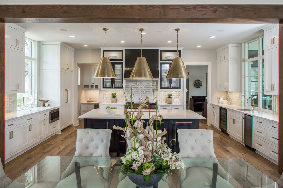 Klassische Wohnküche in U-Form mit braunem Holzboden, Schrankfronten im Shaker-Stil, Küchengeräten aus Edelstahl und Kücheninsel in Austin