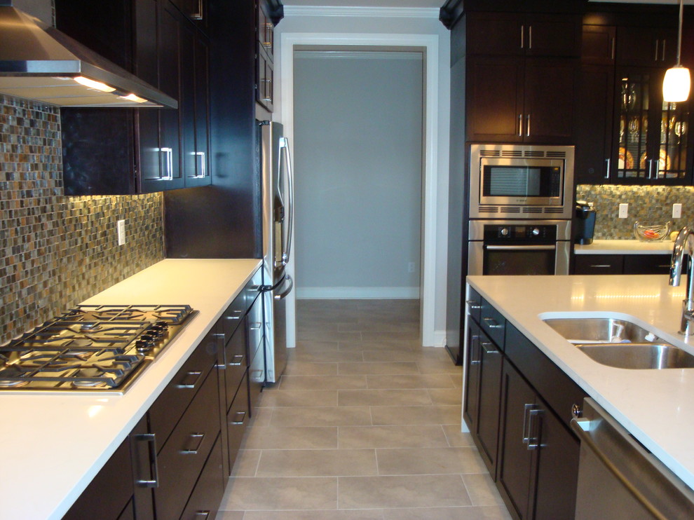 Exempel på ett mellanstort klassiskt linjärt kök med öppen planlösning, med en undermonterad diskho, skåp i shakerstil, skåp i mörkt trä, bänkskiva i kvartsit, flerfärgad stänkskydd, stänkskydd i glaskakel, rostfria vitvaror, klinkergolv i keramik och en köksö