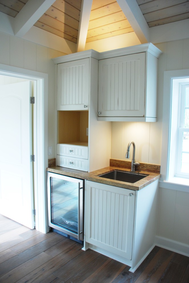Immagine di una piccola cucina lineare chic con lavello sottopiano, ante a persiana, ante bianche, elettrodomestici in acciaio inossidabile e parquet scuro