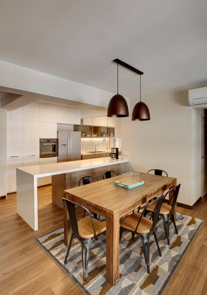 Nordische Wohnküche mit Doppelwaschbecken, Quarzit-Arbeitsplatte, Küchenrückwand in Weiß, Küchengeräten aus Edelstahl, braunem Holzboden, Kücheninsel und Mauersteinen in Singapur