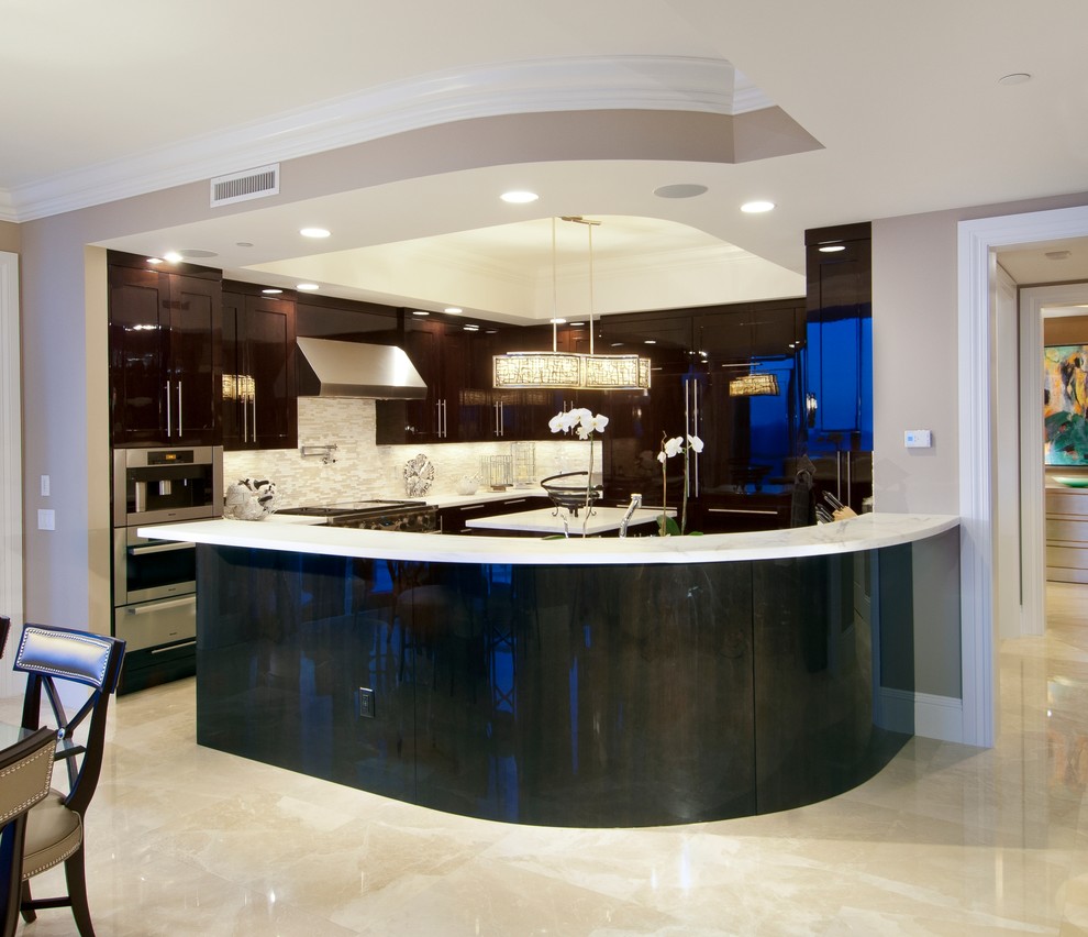 Foto de cocina actual, extra grande, con fregadero bajoencimera, armarios con paneles empotrados, puertas de armario marrones, encimera de cuarcita, salpicadero beige, salpicadero de azulejos en listel, electrodomésticos de acero inoxidable, suelo de mármol y península