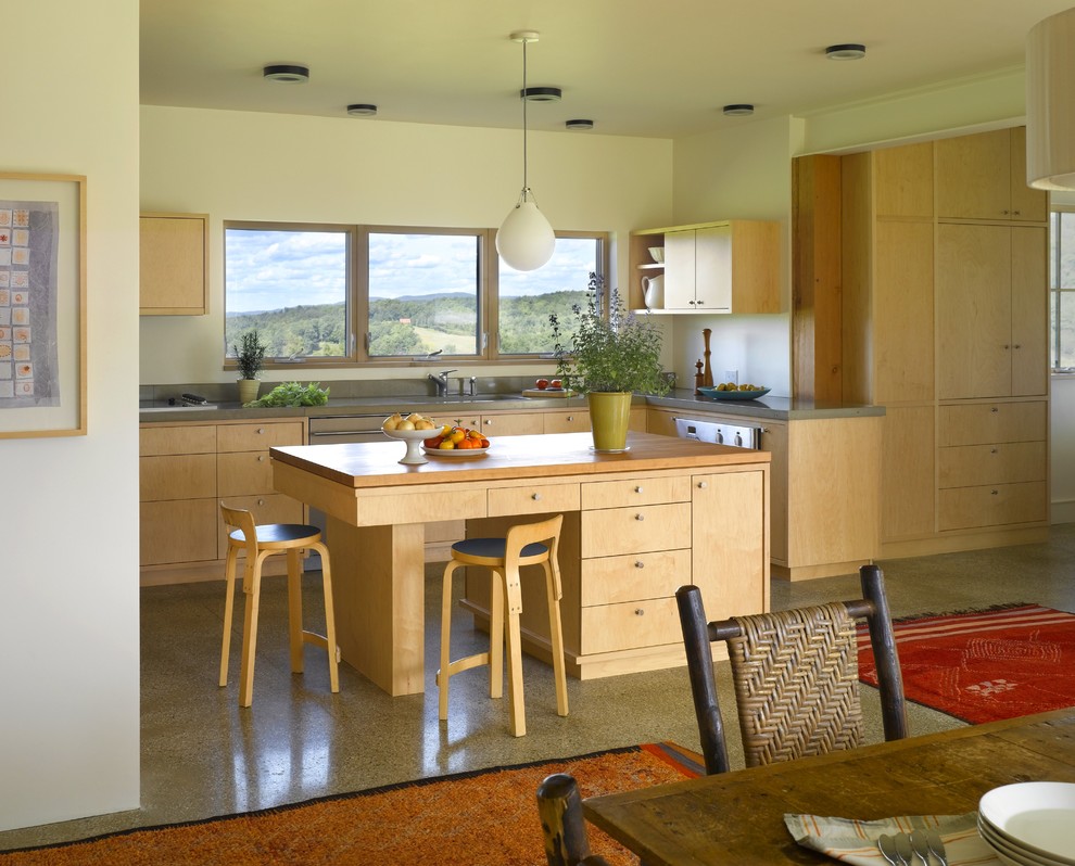 На фото: кухня в стиле кантри с обеденным столом, плоскими фасадами и светлыми деревянными фасадами с