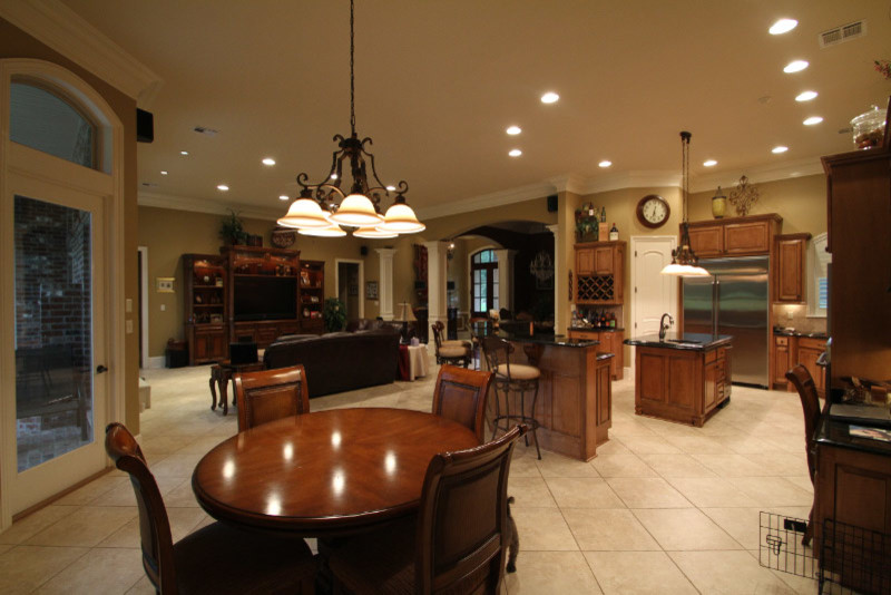 Exempel på ett stort klassiskt kök, med en undermonterad diskho, luckor med upphöjd panel, skåp i mellenmörkt trä, granitbänkskiva, stänkskydd i porslinskakel, rostfria vitvaror, klinkergolv i porslin och en köksö