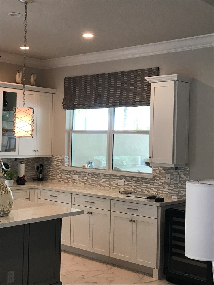 マイアミにある中くらいなトランジショナルスタイルのおしゃれなキッチン (シェーカースタイル扉のキャビネット、白いキャビネット、御影石カウンター、マルチカラーのキッチンパネル、ガラスタイルのキッチンパネル、白い床) の写真
