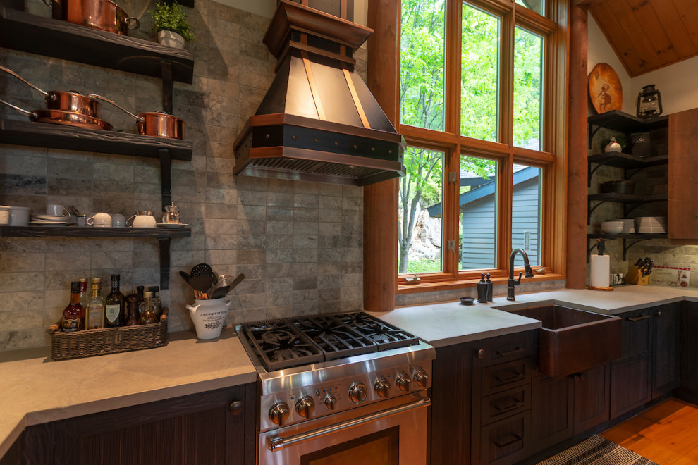 Inredning av ett rustikt mellanstort grå grått kök, med en rustik diskho, släta luckor, skåp i mellenmörkt trä, bänkskiva i betong, grått stänkskydd, stänkskydd i stenkakel, rostfria vitvaror, mellanmörkt trägolv, en köksö och orange golv