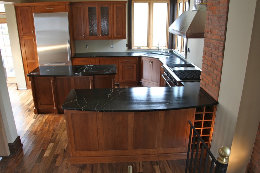 Immagine di una cucina chic di medie dimensioni con lavello sottopiano, ante in stile shaker, ante in legno scuro, elettrodomestici in acciaio inossidabile e pavimento in legno massello medio