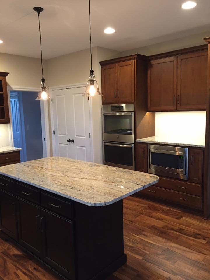 Photo of a medium sized classic u-shaped kitchen/diner in Chicago with a single-bowl sink, shaker cabinets, dark wood cabinets, granite worktops, white splashback, stainless steel appliances, medium hardwood flooring and an island.