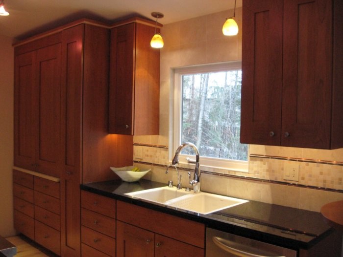 Small modern galley kitchen/diner in Other with a built-in sink, recessed-panel cabinets, medium wood cabinets, light hardwood flooring and no island.