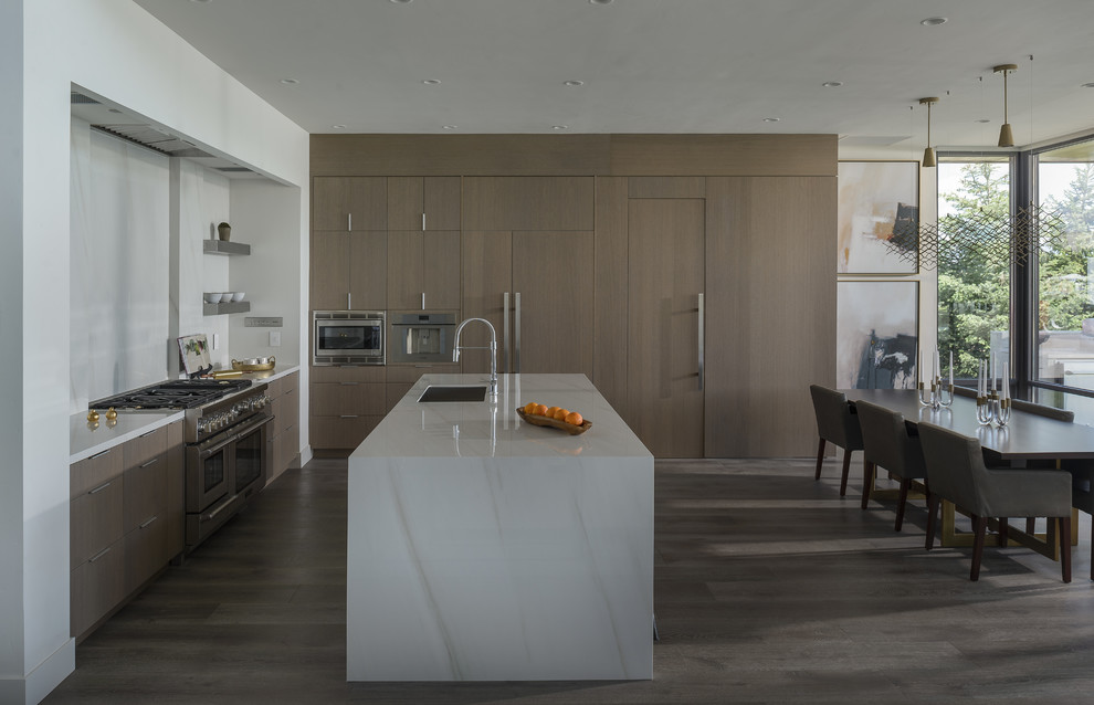 Design ideas for a contemporary l-shaped kitchen/diner in Boise with a submerged sink, flat-panel cabinets, medium wood cabinets, white splashback, stone slab splashback, integrated appliances, medium hardwood flooring, an island, grey floors and white worktops.