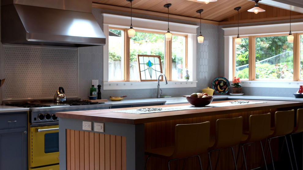 Inspiration for a large craftsman light wood floor enclosed kitchen remodel in Portland with a farmhouse sink, beaded inset cabinets, blue cabinets, quartz countertops, gray backsplash, ceramic backsplash, colored appliances and an island