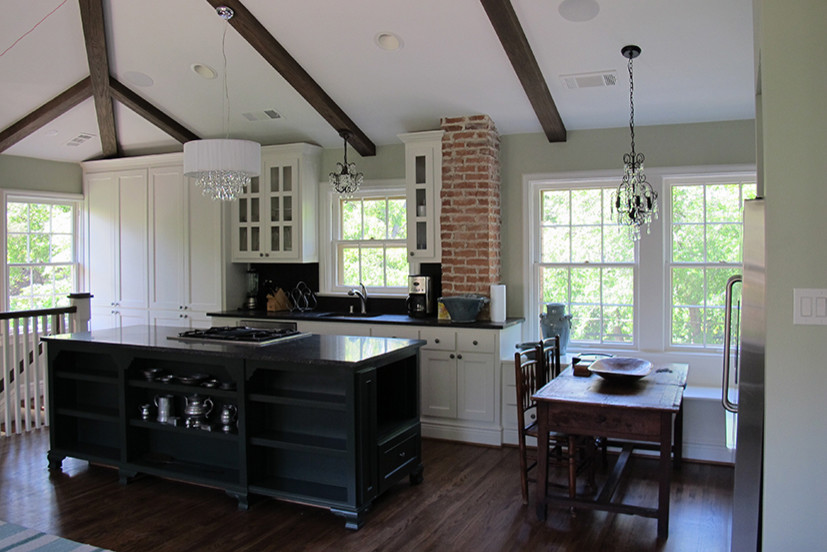 Esempio di una cucina chic di medie dimensioni con ante di vetro, ante bianche, paraspruzzi nero, elettrodomestici in acciaio inossidabile, parquet scuro, lavello sottopiano e pavimento marrone