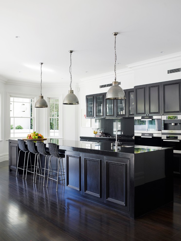 Inspiration for a timeless galley dark wood floor kitchen remodel in Sydney with recessed-panel cabinets, dark wood cabinets, stainless steel appliances and an island