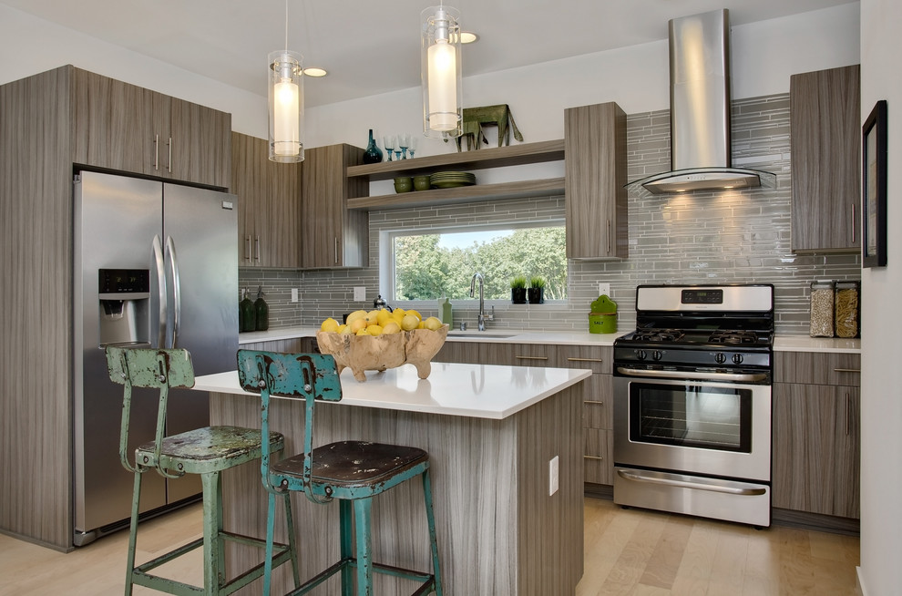 Immagine di una cucina a L minimal con ante lisce, paraspruzzi beige, paraspruzzi con piastrelle a listelli e elettrodomestici in acciaio inossidabile
