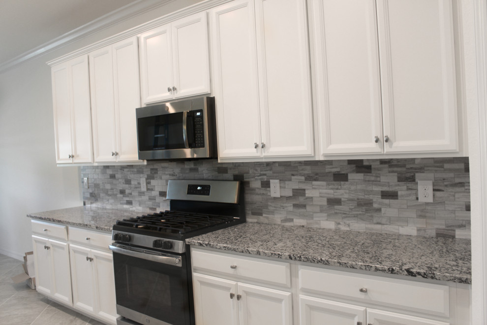 Exempel på ett mellanstort modernt grå grått kök, med vita skåp, grått stänkskydd, stänkskydd i glaskakel, rostfria vitvaror, klinkergolv i keramik, en köksö och grått golv
