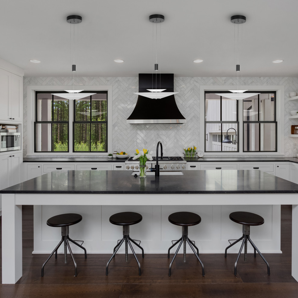Foto di una cucina moderna di medie dimensioni con lavello da incasso, ante bianche, top in onice, paraspruzzi grigio, paraspruzzi con piastrelle a mosaico, elettrodomestici neri, pavimento in compensato, pavimento marrone e top nero