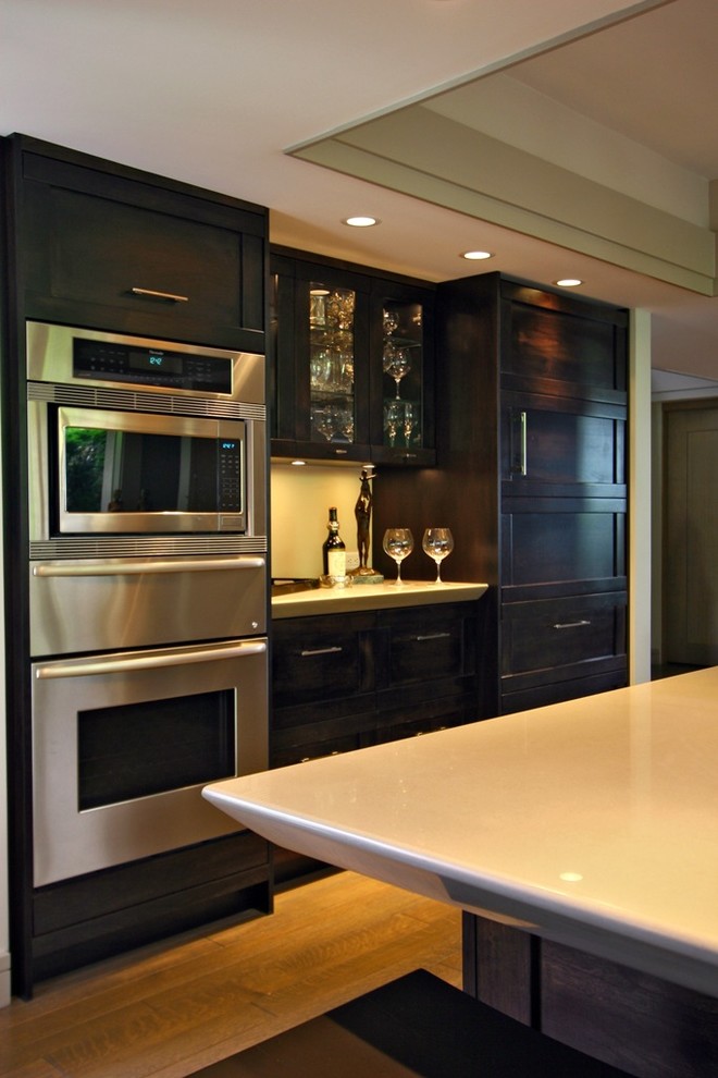 バンクーバーにある広いアジアンスタイルのおしゃれなキッチン (シェーカースタイル扉のキャビネット、濃色木目調キャビネット、シルバーの調理設備) の写真