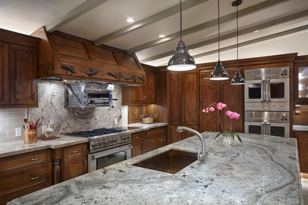 Exempel på ett mycket stort klassiskt kök, med en undermonterad diskho, luckor med infälld panel, skåp i slitet trä, granitbänkskiva, grönt stänkskydd, stänkskydd i keramik, färgglada vitvaror, betonggolv och en köksö