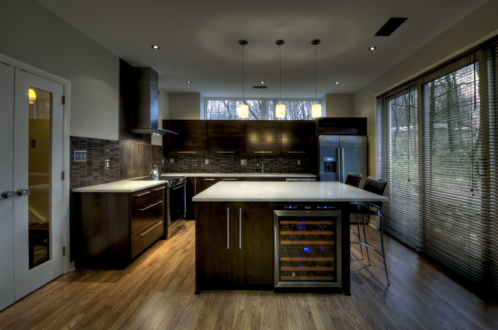 Example of a mid-sized trendy l-shaped medium tone wood floor open concept kitchen design in DC Metro with an undermount sink, flat-panel cabinets, dark wood cabinets, quartz countertops, multicolored backsplash, matchstick tile backsplash, stainless steel appliances and an island