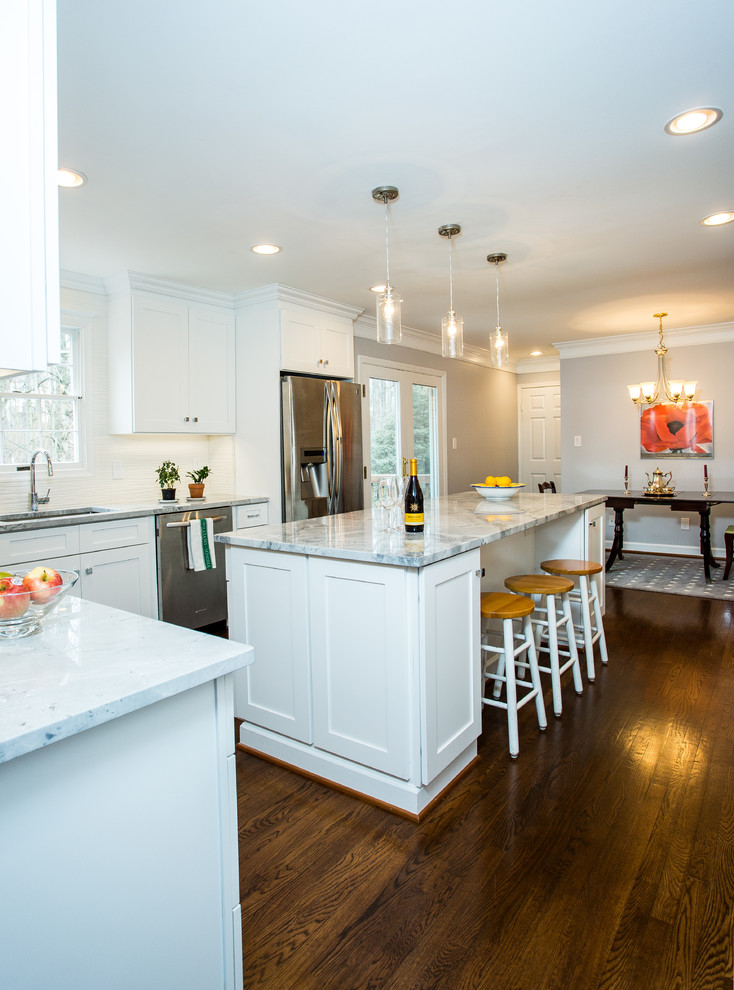 Inspiration for a large transitional l-shaped dark wood floor eat-in kitchen remodel in DC Metro with an undermount sink, shaker cabinets, white cabinets, granite countertops, white backsplash, porcelain backsplash, stainless steel appliances and an island