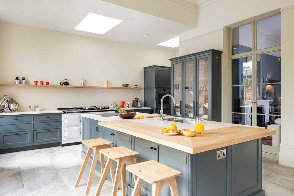 This is an example of an expansive traditional u-shaped kitchen in Berkshire with wood worktops, porcelain flooring, an island, a submerged sink, shaker cabinets, blue cabinets, grey floors and white worktops.