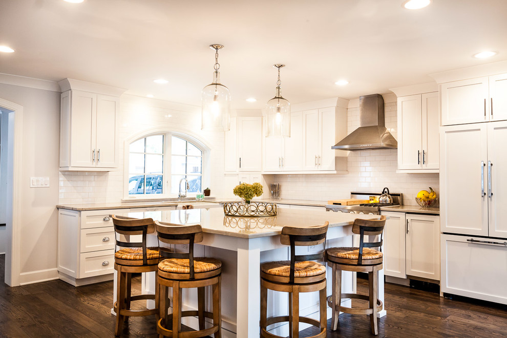 Inspiration for a large eclectic l-shaped medium tone wood floor open concept kitchen remodel in Chicago with a farmhouse sink, shaker cabinets, white cabinets, quartzite countertops, white backsplash, ceramic backsplash, stainless steel appliances and an island