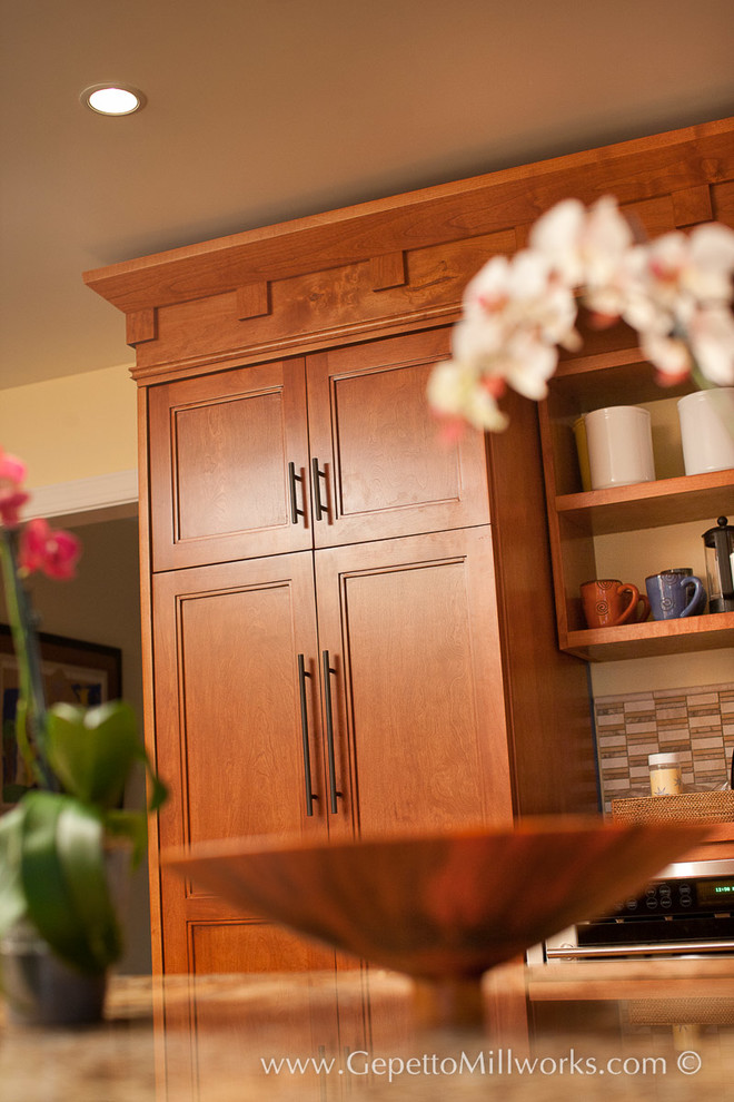 Bild på ett litet amerikanskt kök, med luckor med upphöjd panel, skåp i mellenmörkt trä, granitbänkskiva, beige stänkskydd, stänkskydd i keramik, rostfria vitvaror, mellanmörkt trägolv och en köksö