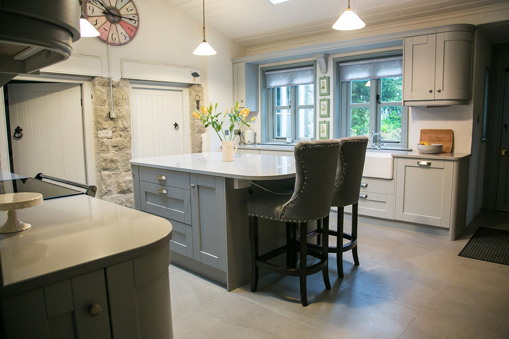 Zweizeilige Landhaus Küche mit Schrankfronten mit vertiefter Füllung, grauen Schränken, Kücheninsel und grauem Boden in Sonstige