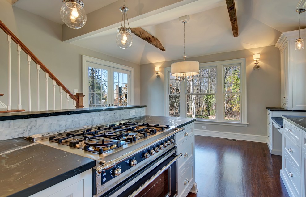 Ornate single-wall dark wood floor kitchen photo in New York with a farmhouse sink, soapstone countertops and an island