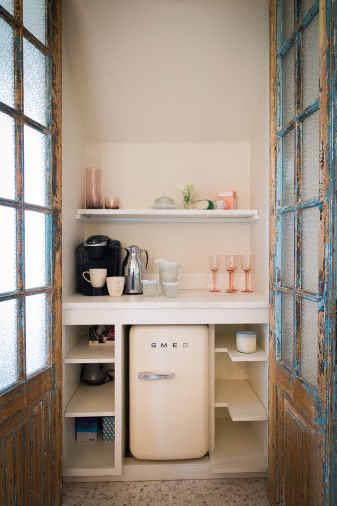 Cette image montre une petite cuisine style shabby chic avec un placard sans porte, des portes de placard blanches et un électroménager blanc.