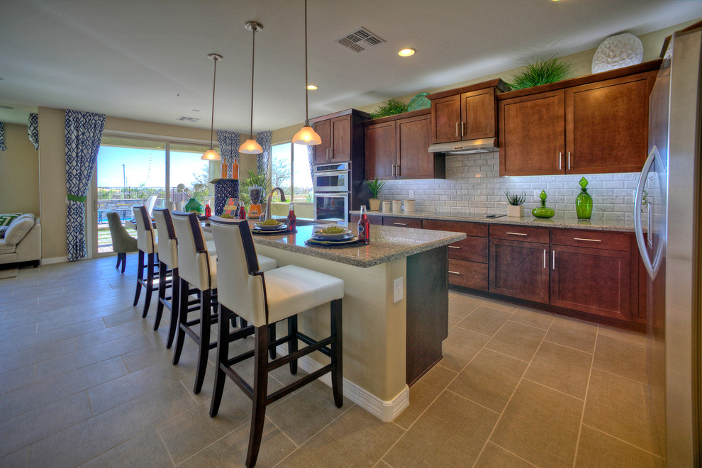 Example of a huge transitional l-shaped ceramic tile open concept kitchen design in Phoenix with a single-bowl sink, flat-panel cabinets, medium tone wood cabinets, granite countertops, gray backsplash, ceramic backsplash, stainless steel appliances and an island