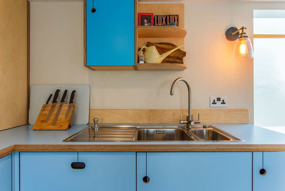 Идея дизайна: угловая кухня среднего размера в стиле фьюжн с обеденным столом, плоскими фасадами, бирюзовыми фасадами, столешницей из ламината, полуостровом и синей столешницей