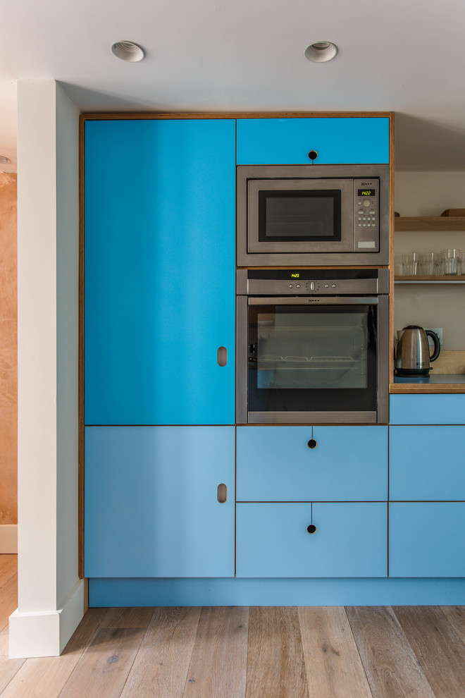 サセックスにある高級な中くらいなエクレクティックスタイルのおしゃれなキッチン (フラットパネル扉のキャビネット、ターコイズのキャビネット、ラミネートカウンター、青いキッチンカウンター) の写真