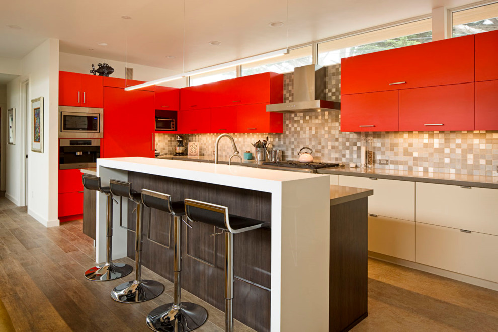 Example of a trendy l-shaped medium tone wood floor kitchen design in San Francisco with flat-panel cabinets, white cabinets, beige backsplash, stainless steel appliances and an island